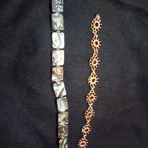 Two bracelets, one gold tone with purple stones, one with Onyx like shell.